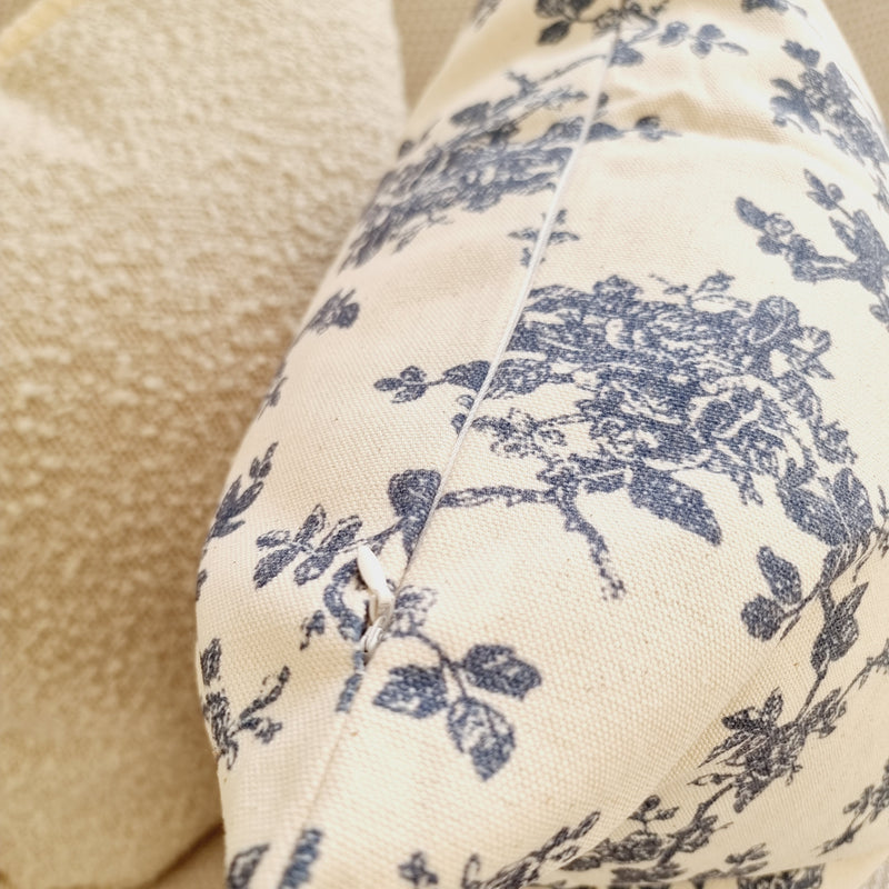 close up of zip on cream cushion cover with navy flora design