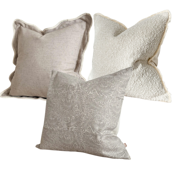 Set of 3 Square cushions, 1 x greige with a cram scalloped edge, 1 x cream boucle, 1 x beige leaf print with a cream background. All on a white background