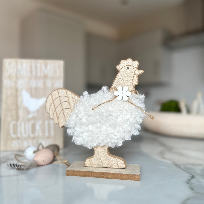 decorative wooden chicken with white fluffy body and a wooden daisy necklace