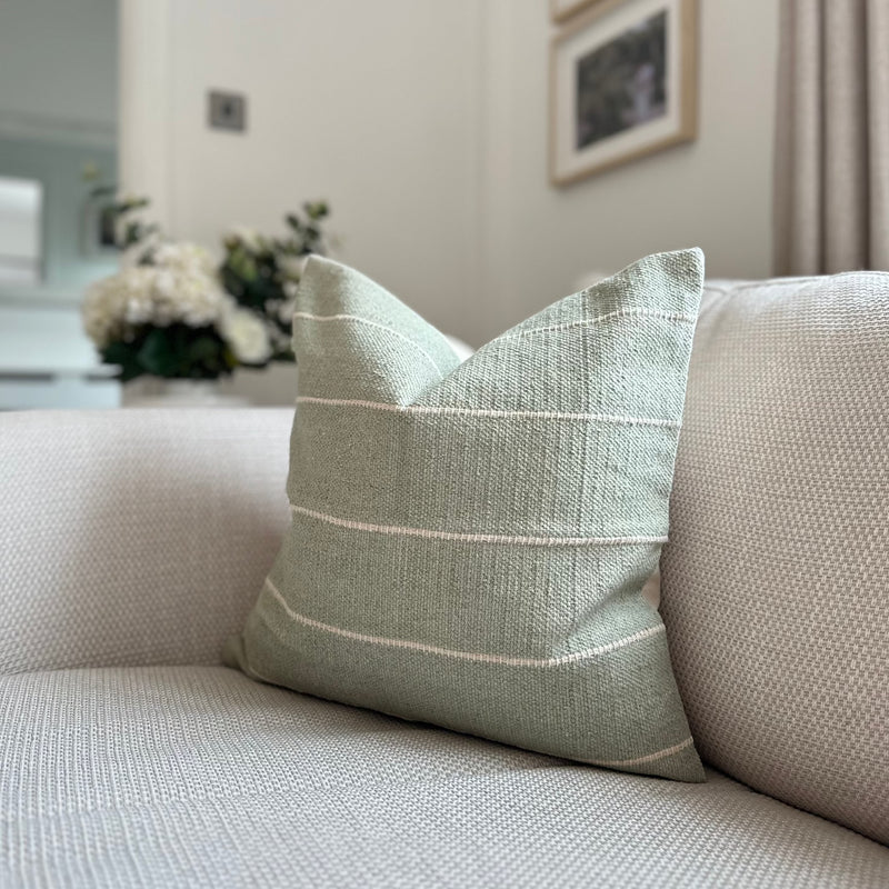 Duck Egg soft Green Square Cushion with Horizontal cream stripe throughout. Sat on a cream sofa in a living room