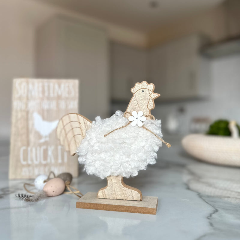 decorative wooden chicken with white fluffy body and a wooden daisy necklace