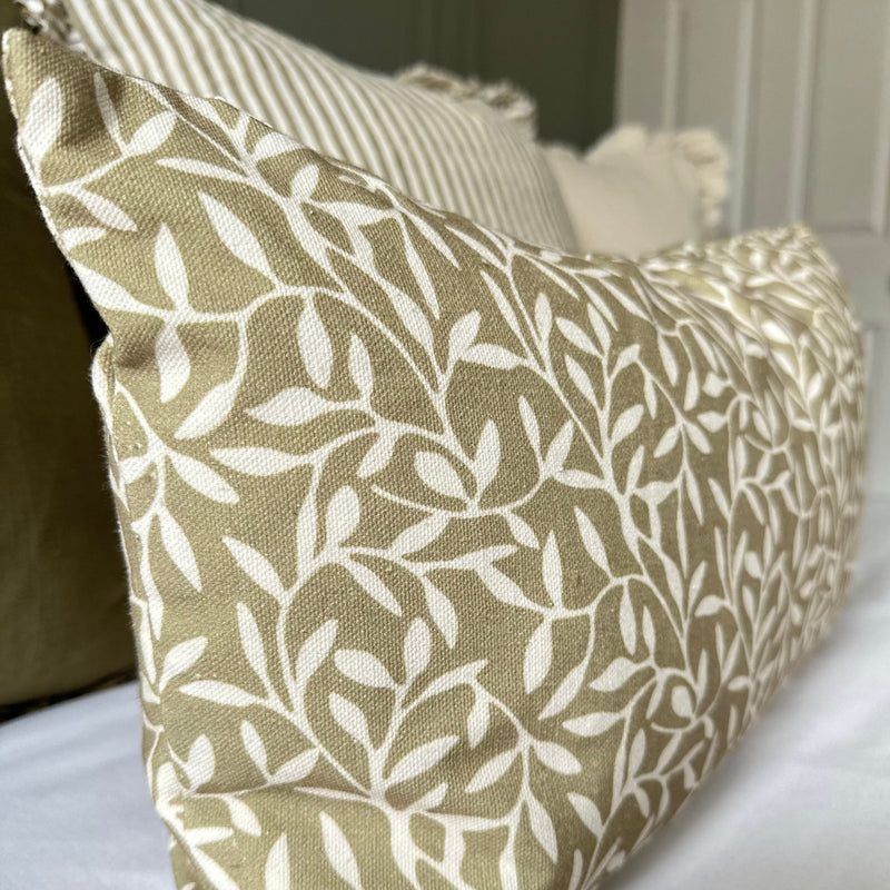 close up of olive coloured rectangle cushion with a cream all over cream leaf print.