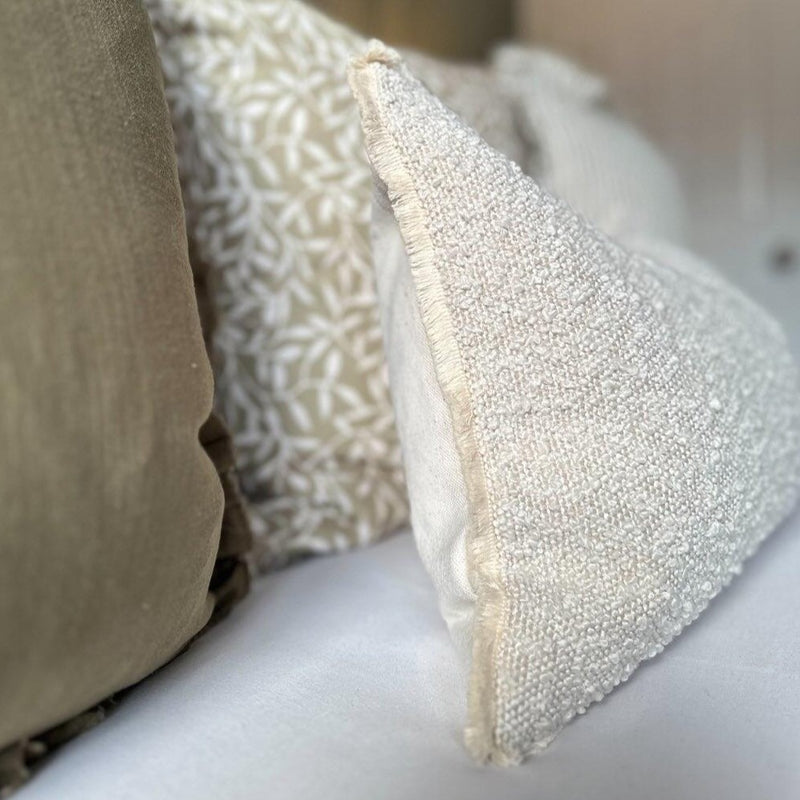 CLOSE UP OF THE SIDE OF THE CREAM BOUCLE RECTANGLE CUSHION