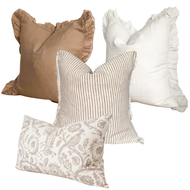 Set of 4 brown and cream country inspired cushions. 1 Square ruffled linen brown cushion. 1 square ruffled edge cream cushions, 1 weathered edge linen cream and brown vertical striped cushion, 1 rectangle cotton cream cushion with large all over brown floral and pheasant country print