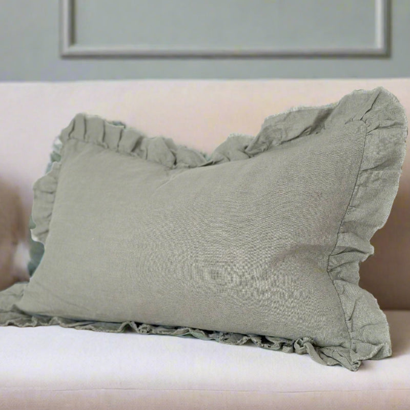 rectangle ruffled edge sage green linen cushion. Sat on a cream sofa.