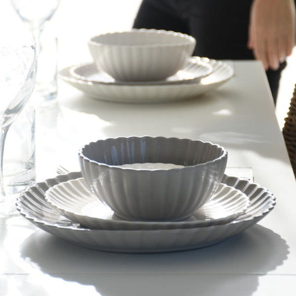 Grey floral ceramic bowls with a scalloped edge and a matt finish. These bowls feature a beautiful floral shape and a glazed top, adding an elegant touch to any table setting. Available in small and large sizes, these bowls are perfect for serving various dishes.