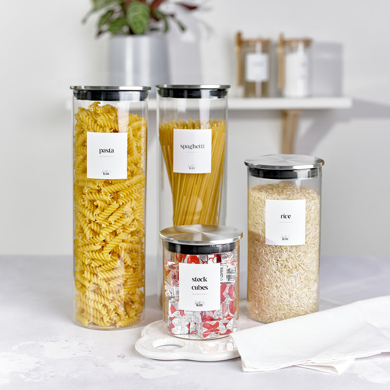 4 clear glass jars with stainless steel lids storing pasta, spaghetti, rice, stock cubes