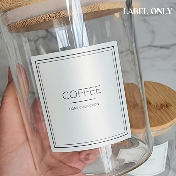 Cream square label with coffee written on in capitals, black line under with Home Collection written under it in capitals, stuck on a glass jar with bamboo lid