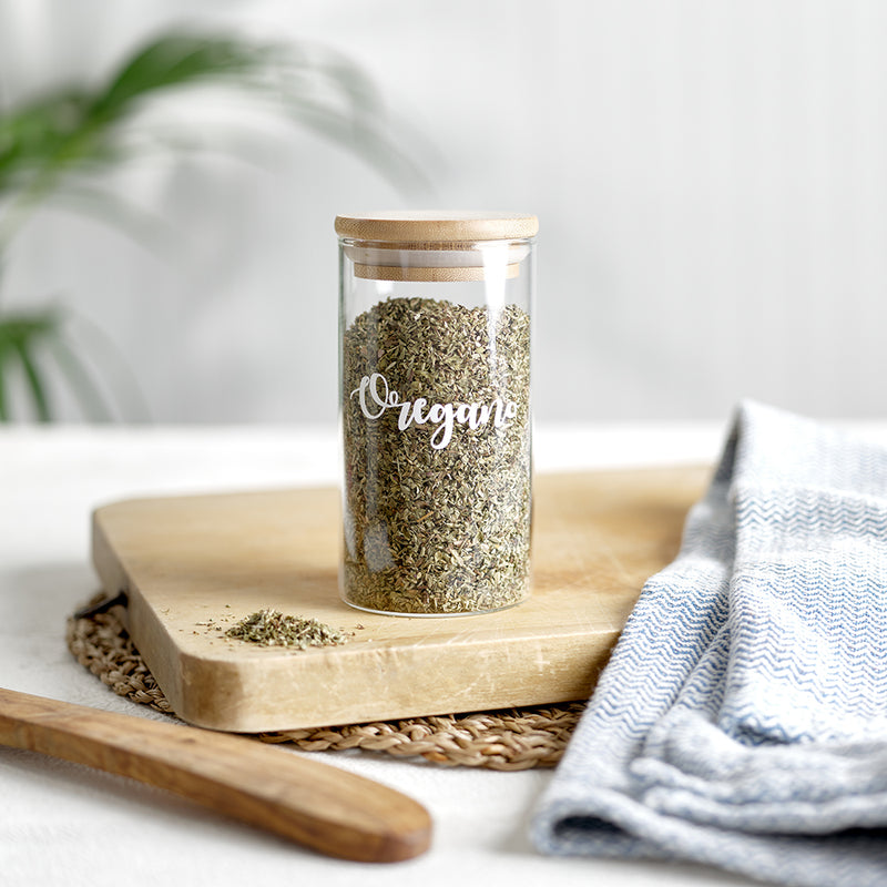  Glass jars with bamboo airtight lids with white vinyl  label for herbs and spices. Sat on a bamboo chipping board