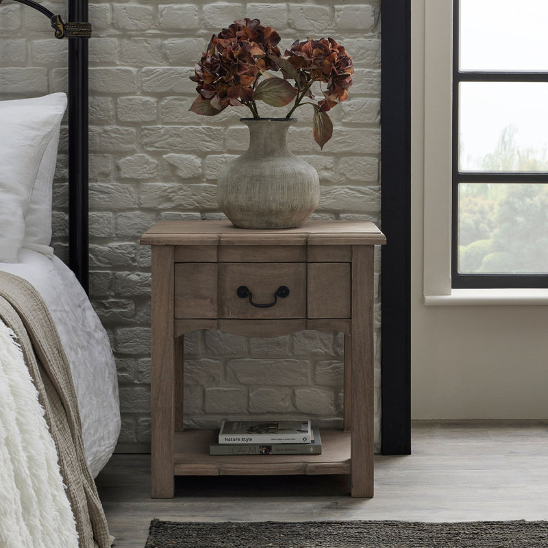 Wooden bedside table. With 1 top drawer with a black metal handle and a bottom shelf styled with a book 