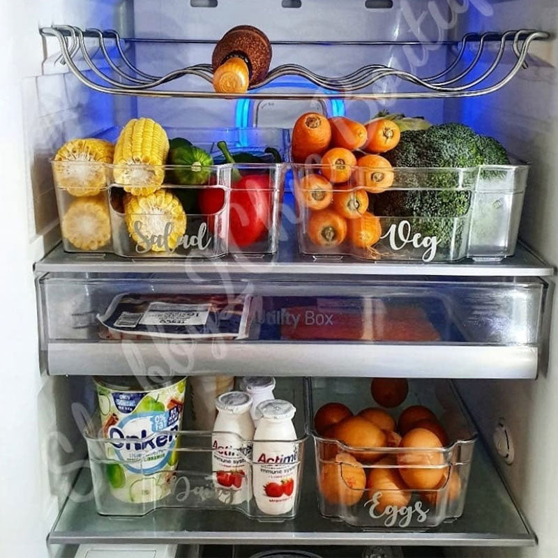 Several  containers inside an organised fridge, each with personised wording and is filled with their respective item, Dairy, eggs, Veg and Salad.